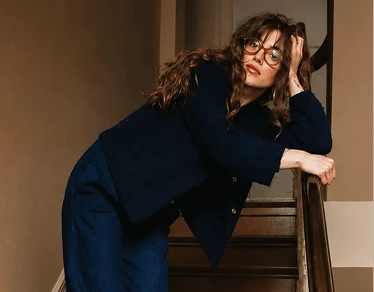A woman leaning on a staircase railing
