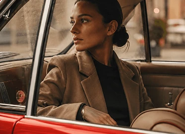 A woman looking out of a red car