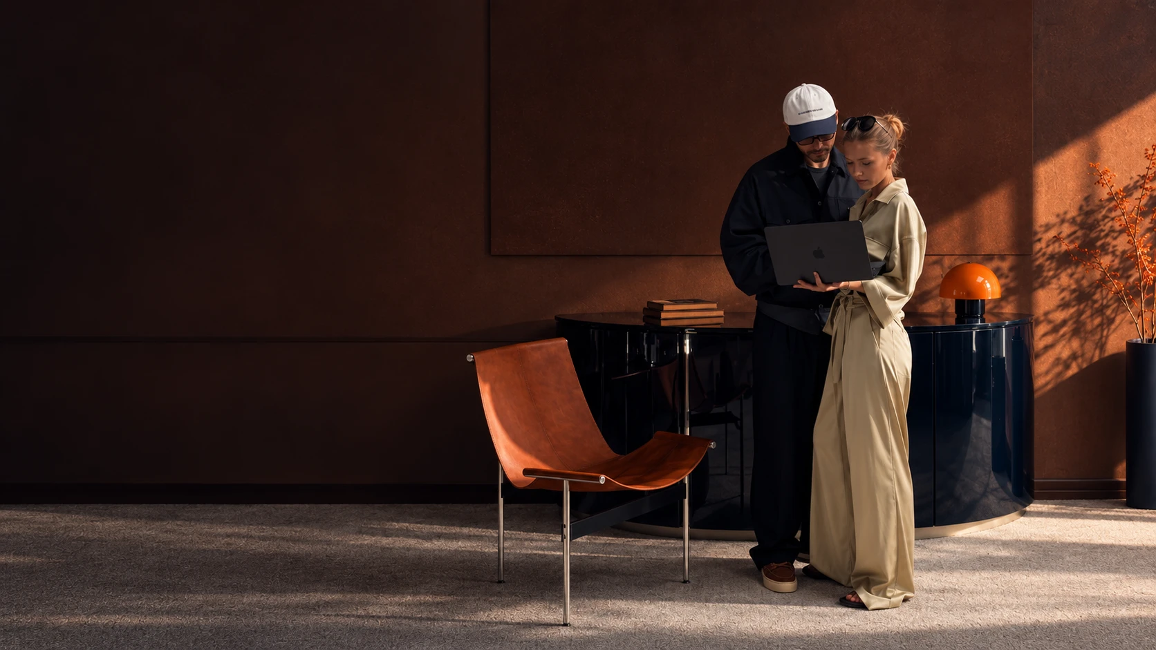 Two people looking at a laptop in a dim office