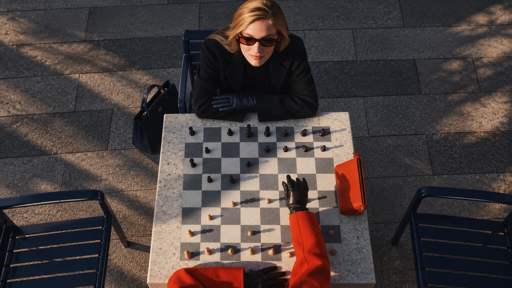 A woman in sunglasses playing chess outdoors